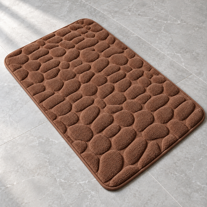Coffee brown 3D cobblestone non-slip bath mat on a bathroom floor