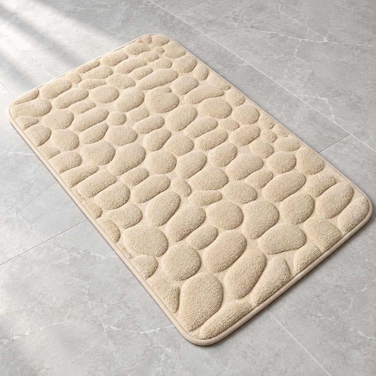 Cream 3D cobblestone non-slip bath mat on a bathroom floor