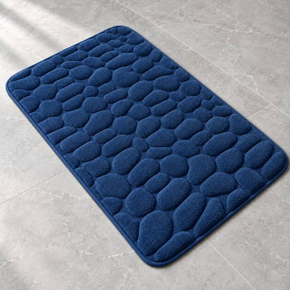 Navy blue 3D cobblestone non-slip bath mat on a bathroom floor