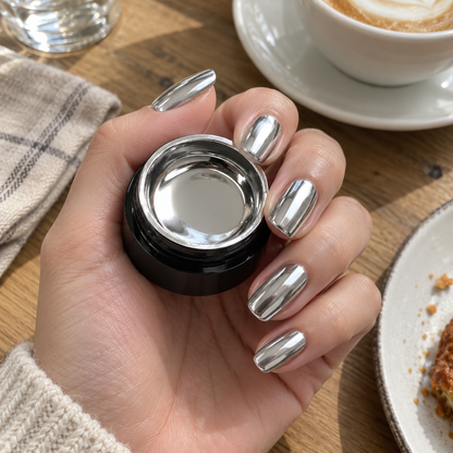 Hand with mirror chrome nails holding the gel polish jar at a cafe