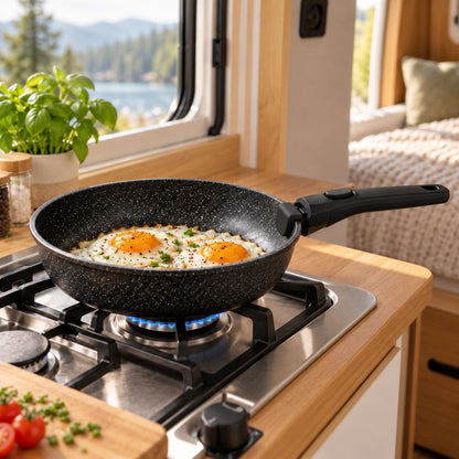 Black frying pan cooking breakfast in a compact camper kitchen