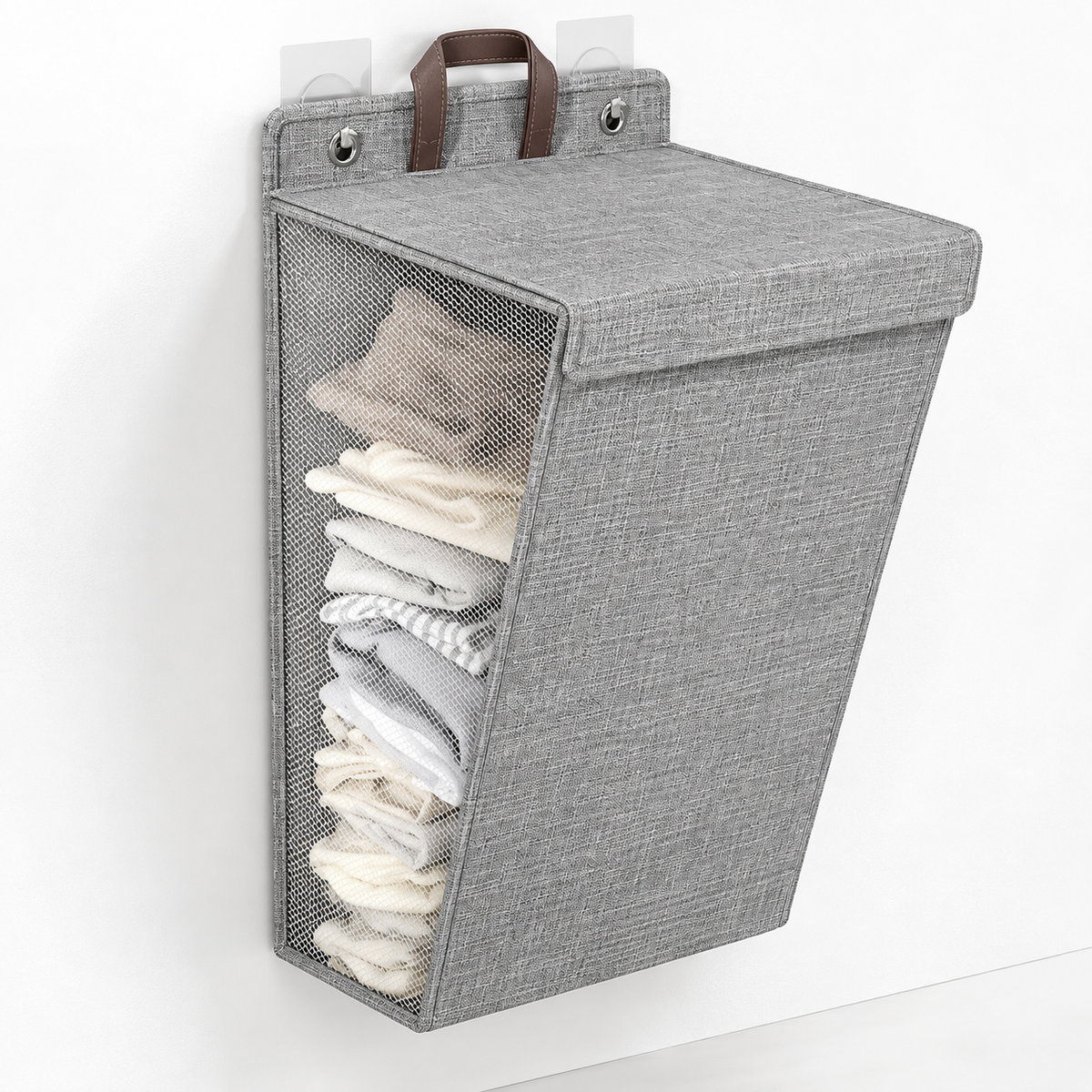 Gray wall-hanging laundry hamper with a lid, mesh side panel and brown handle on adhesive hooks
