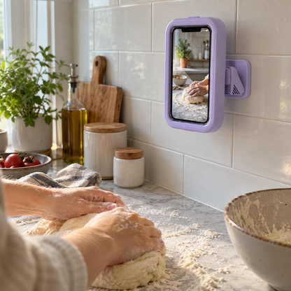 Purple phone holder on a kitchen backsplash showing a recipe while kneading dough