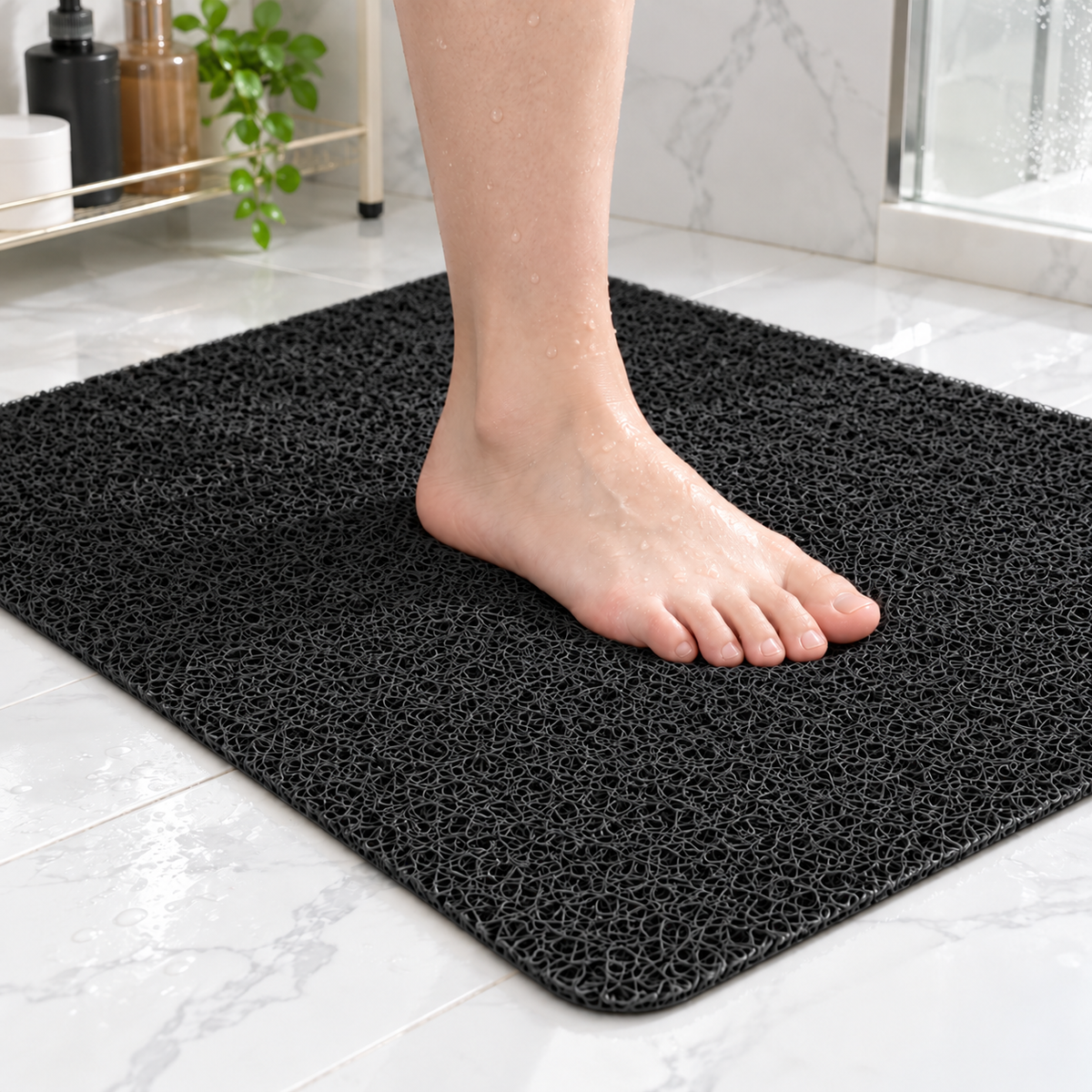 Bare foot standing on a black loofah shower mat