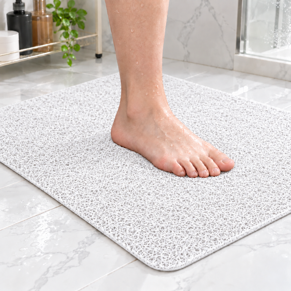 Bare foot standing on a white loofah shower mat