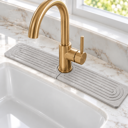Light grey diatomite sink mat, 23.6 in, around a brass faucet on white marble