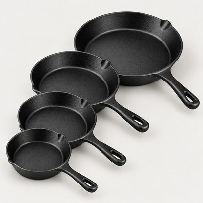 Four pre-seasoned cast iron skillets, 14, 16, 20 and 26 cm, in a staggered row